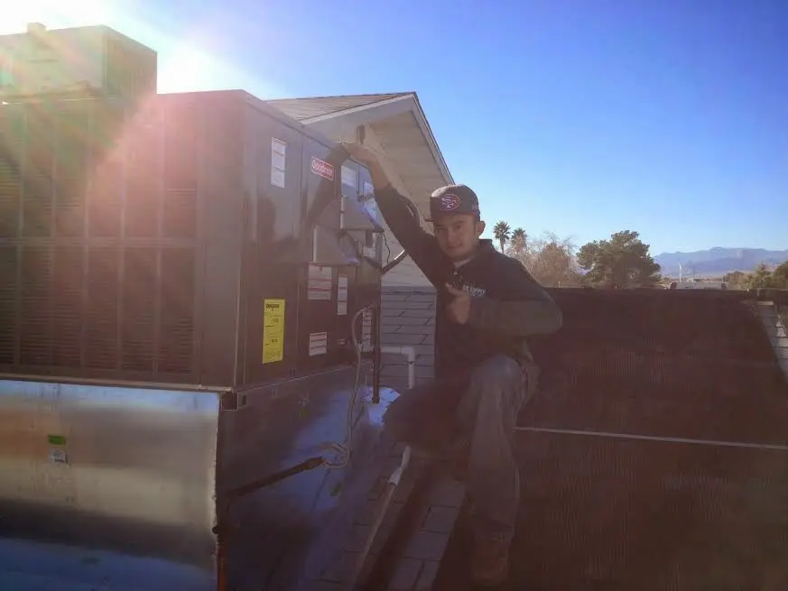 HVAC technician performing AC Tune-Up on a rooftop unit in Palos Hills